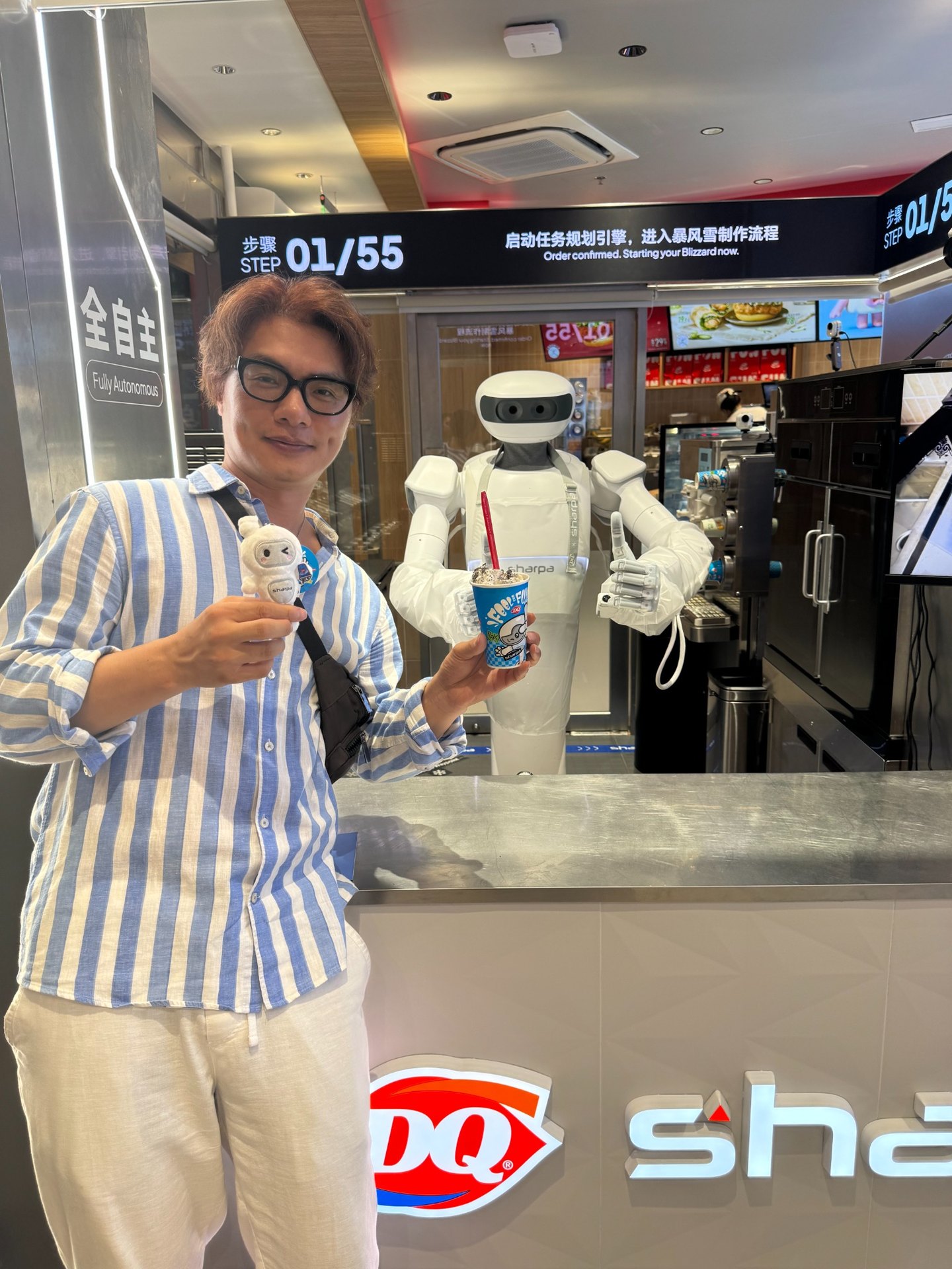 상하이 우장루 DQ Blizzard & Burgers에서 블리자드를 든 Henry Chan Jung과 Sharpa 휴머노이드 로봇